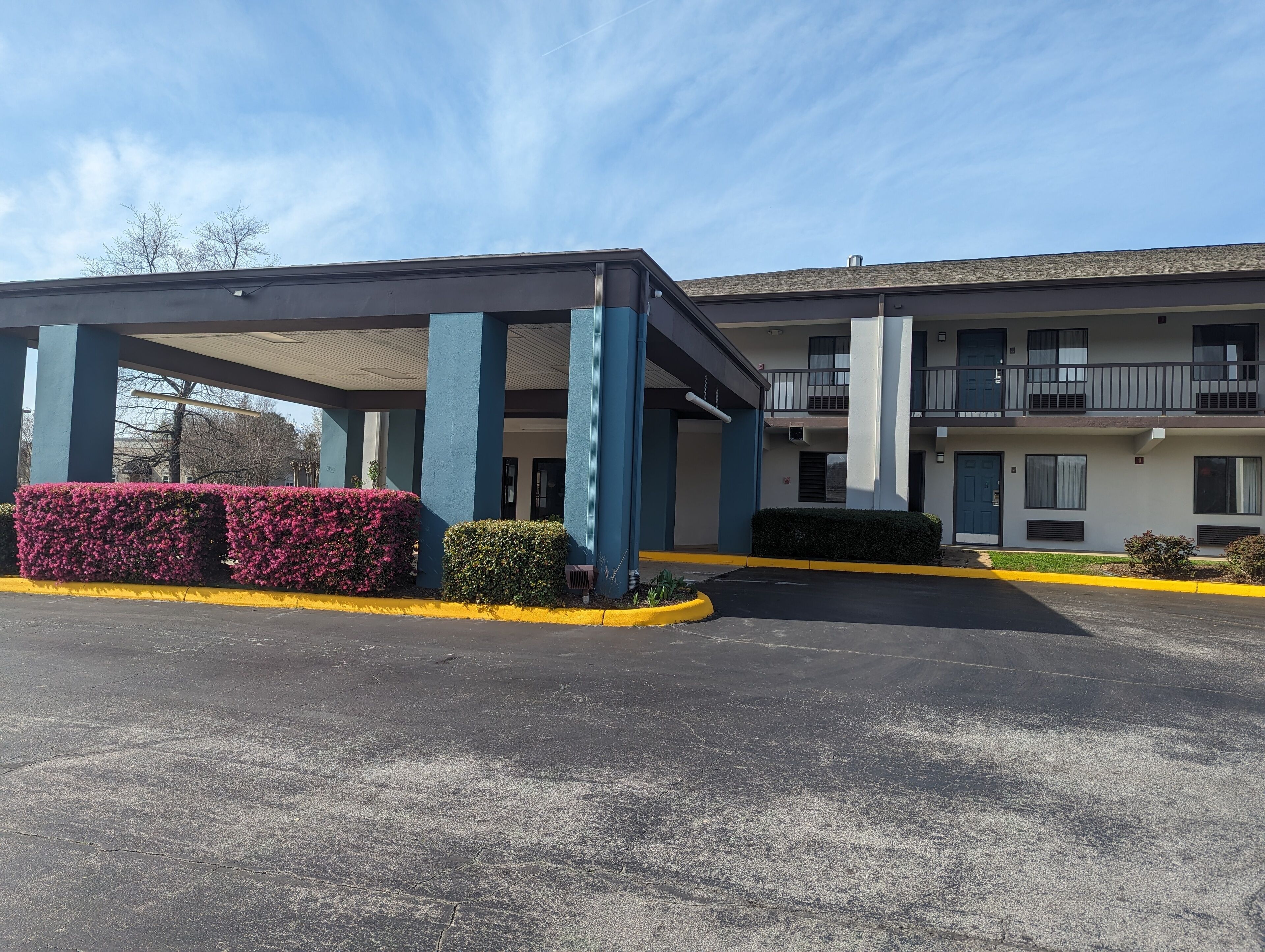 A two-story motel with a covered parking area, a central entrance, and a balcony on the upper floor.