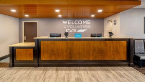 A reception desk with a "Welcome to the Volunteer State" sign, a Hilton Express check-in, and a phone.