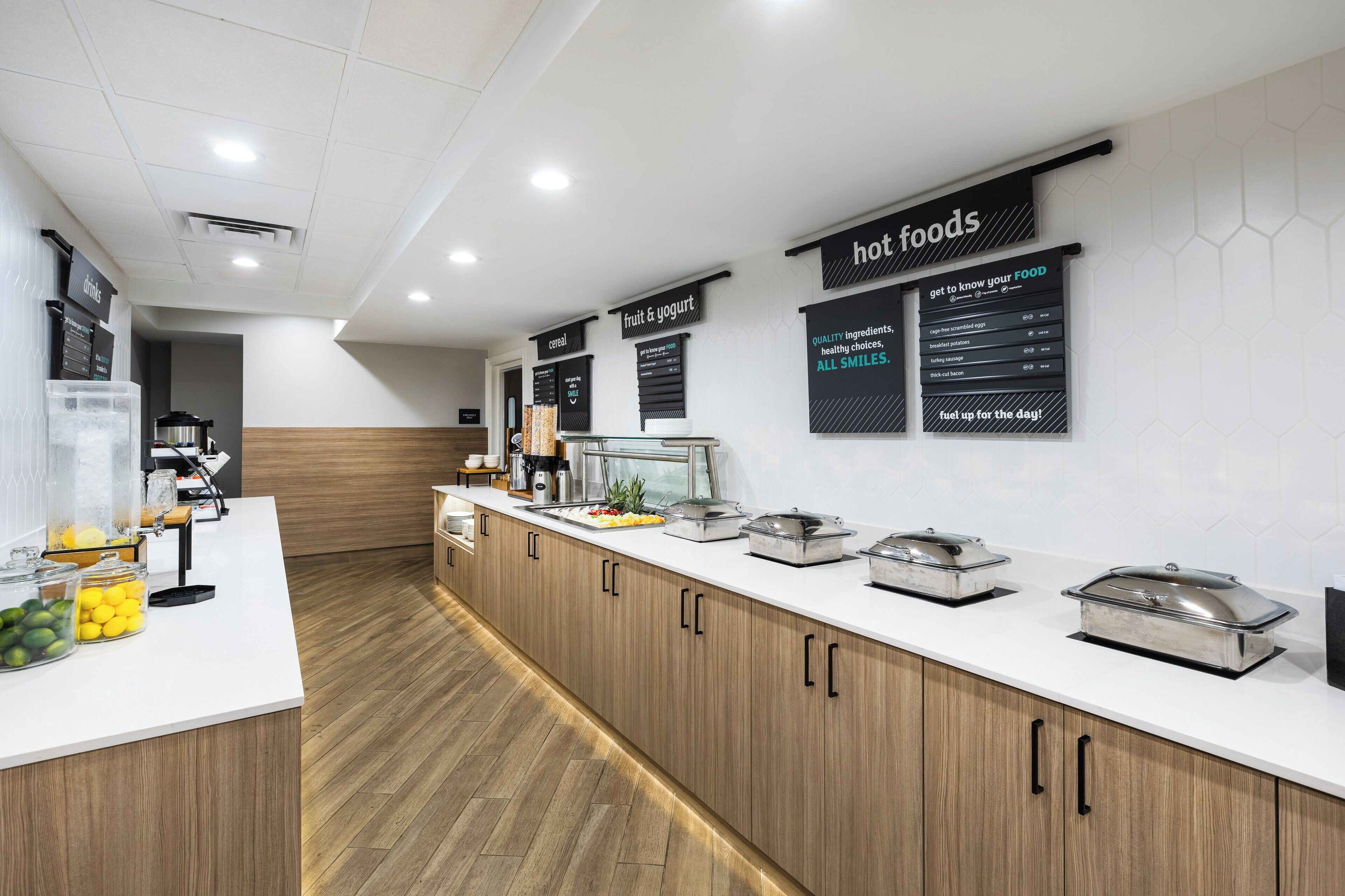 A modern breakfast bar with labeled sections for hot foods, cereal, and fruit & yogurt.