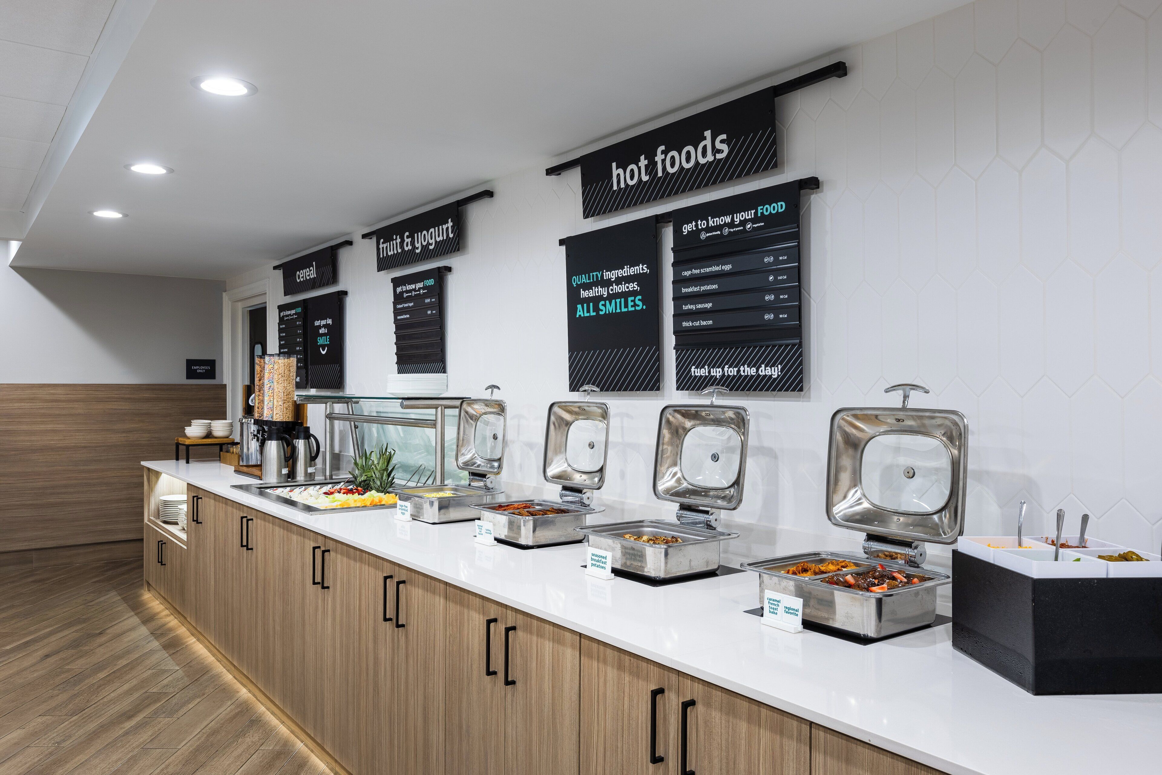 A buffet area with various food stations labeled, including 'cereal', 'fruit & yogurt', and 'hot foods'.