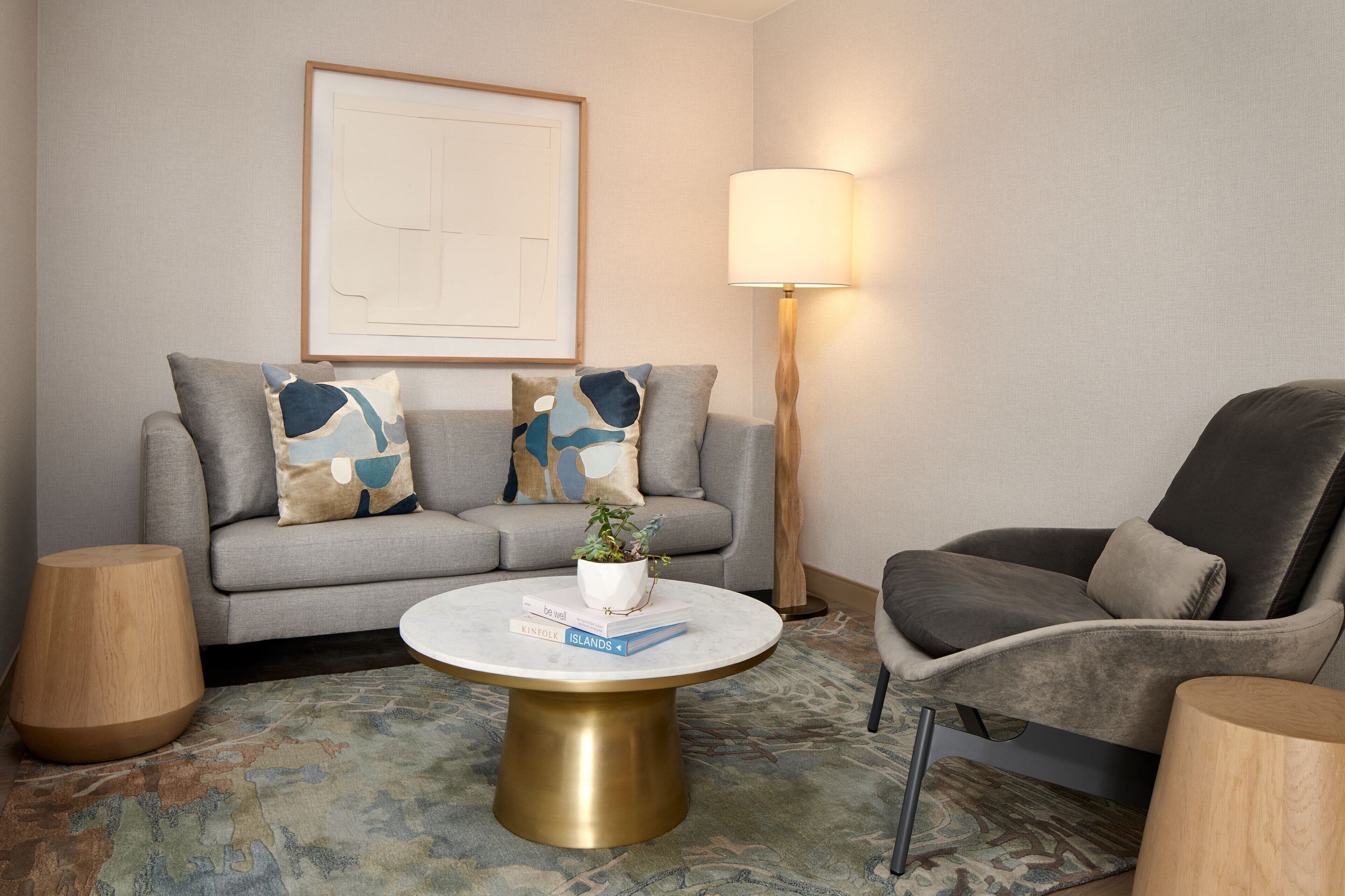 A modern living room with a grey sofa, a round coffee table, and a floor lamp.