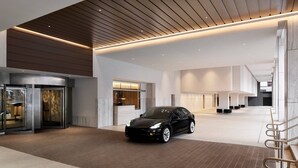 A modern lobby with a black car parked in the center, a reception desk, and a staircase leading to upper floors. - The Westin DC Downtown (Washington)