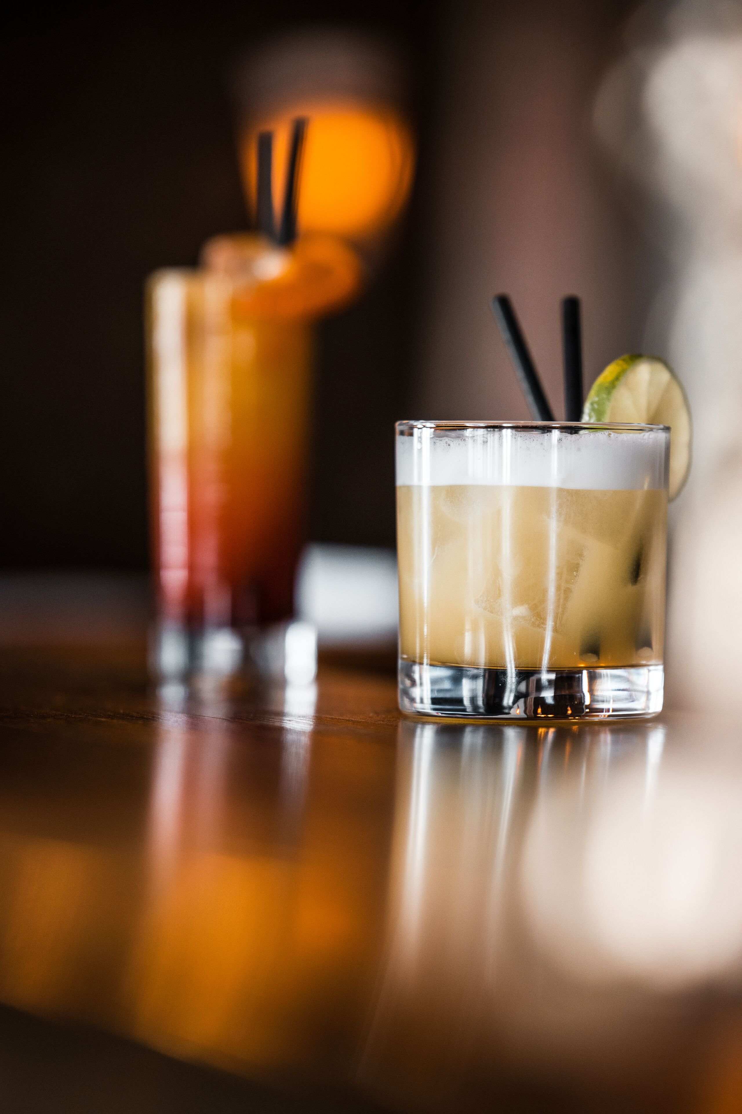 Dos vasos de bebidas heladas sobre una superficie de madera.
