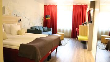 Una habitación de hotel con una cama, un sofá, un escritorio y una silla.