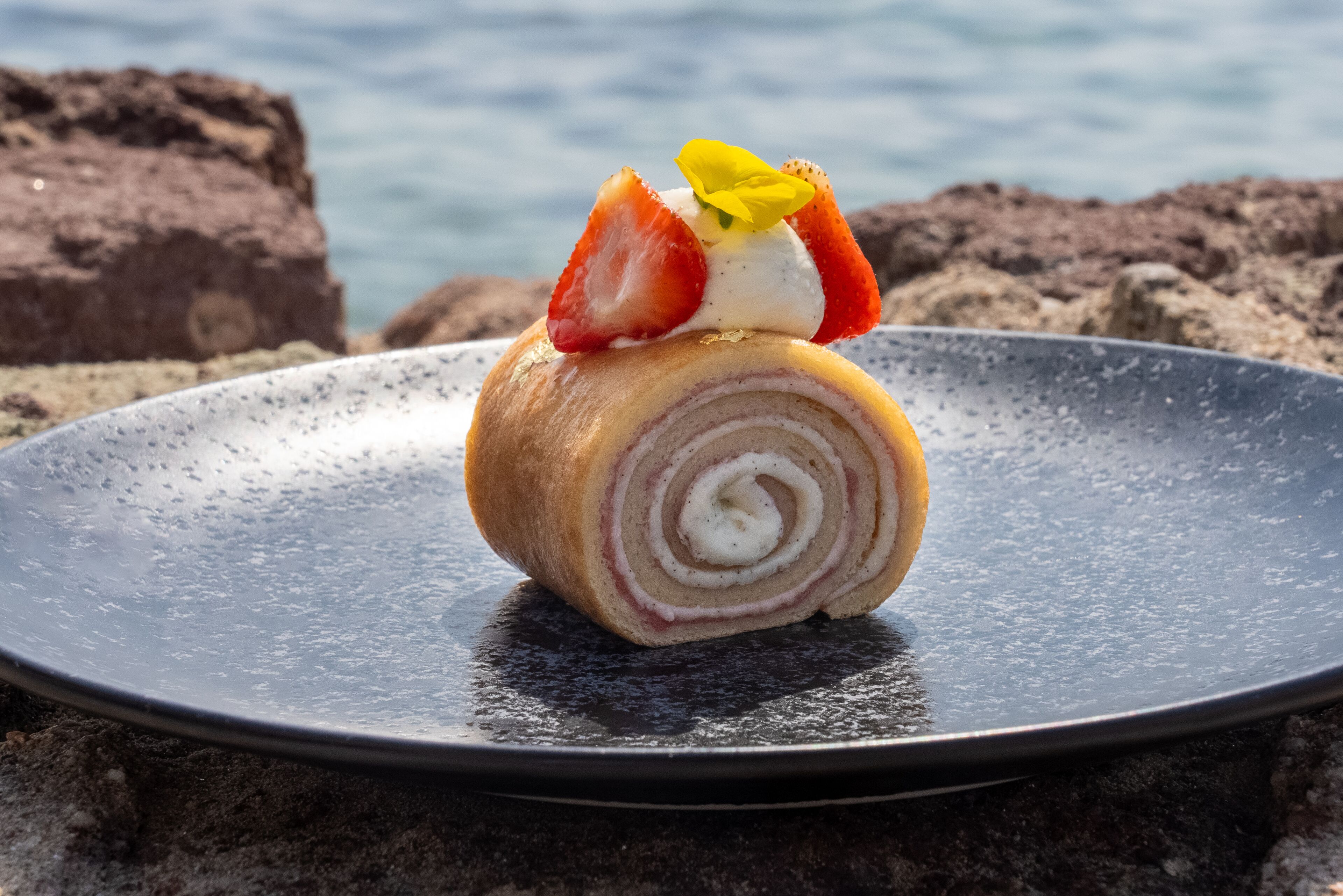 A dessert on a plate with a coastal background.