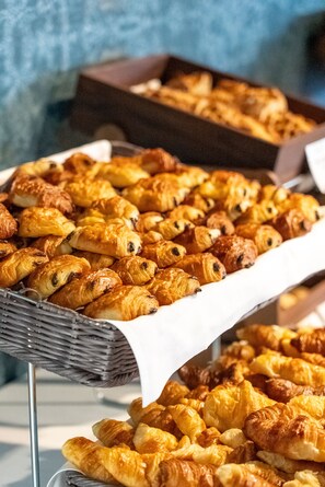A display of assorted pastries, including croissants and other baked goods, arranged on a table.