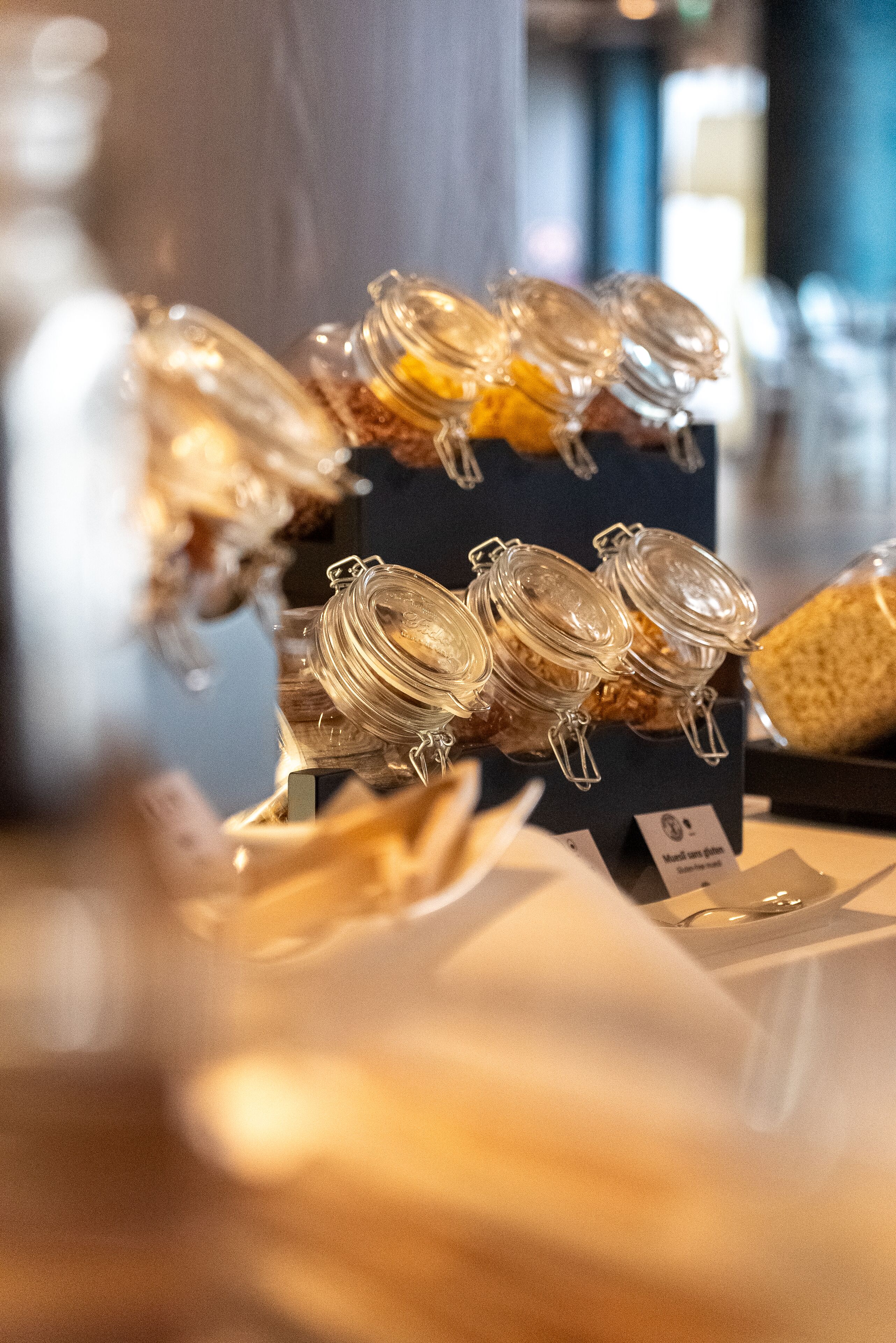 A display of glass jars with lids, likely containing food items, on a table with a sign that reads "Made with love."