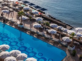 Una piscina al aire libre de temporada, sombrillas