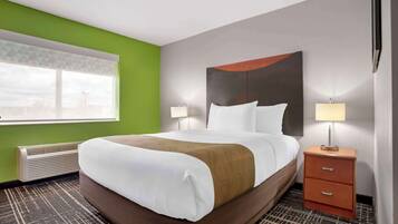 Une chambre d’hôtel avec un lit, des tables de chevet et une fenêtre avec des stores.