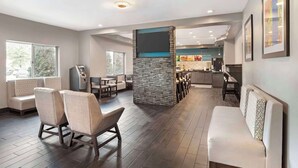 A modern interior with seating areas, a kitchen, and a bar. - Quality Inn & Suites Birmingham - Highway 280 (Birmingham)