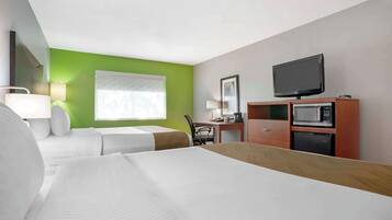 A hotel room with two beds, a desk with a chair, a television, and a microwave.