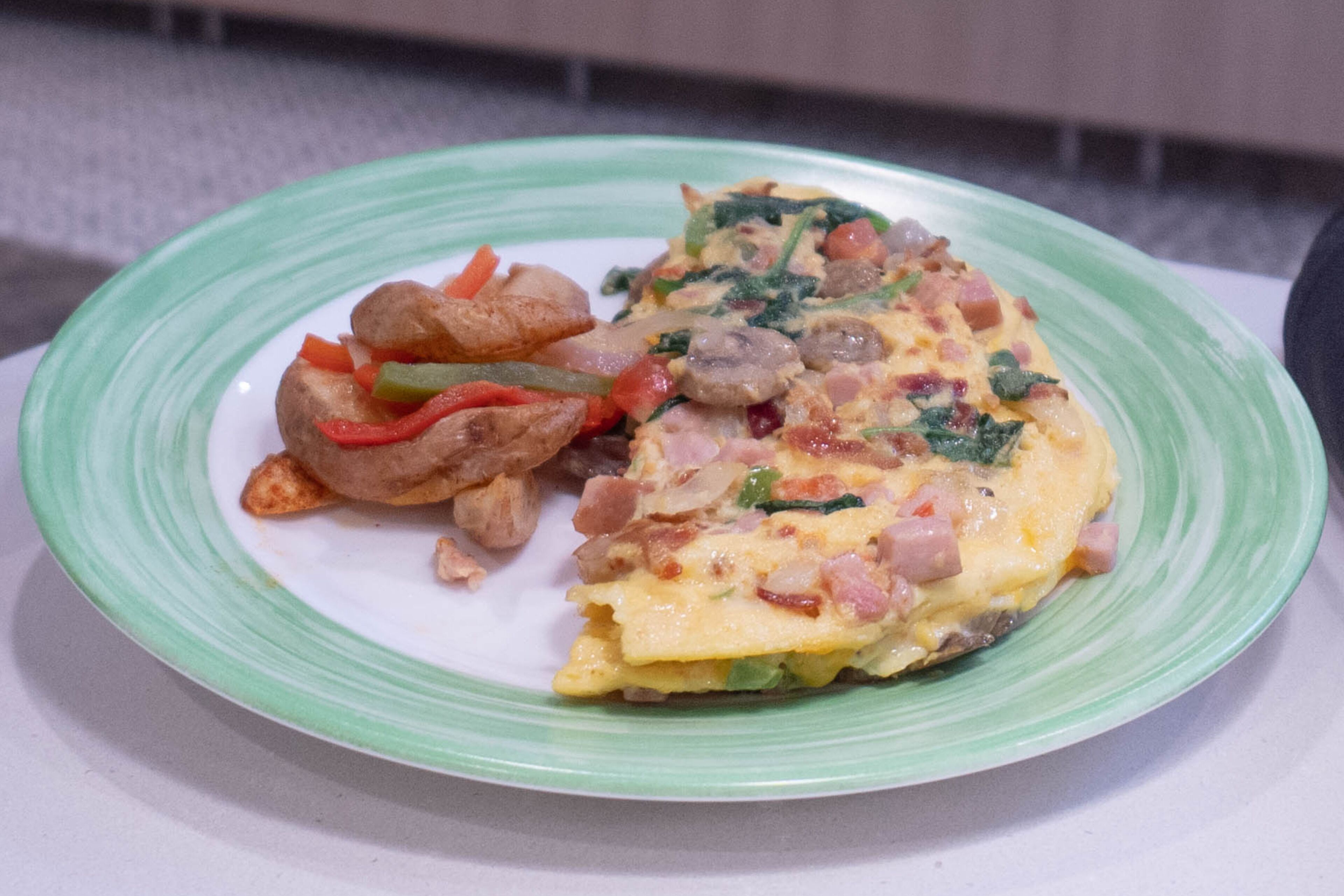 Un plato con una porción de tortilla y verduras fritas.