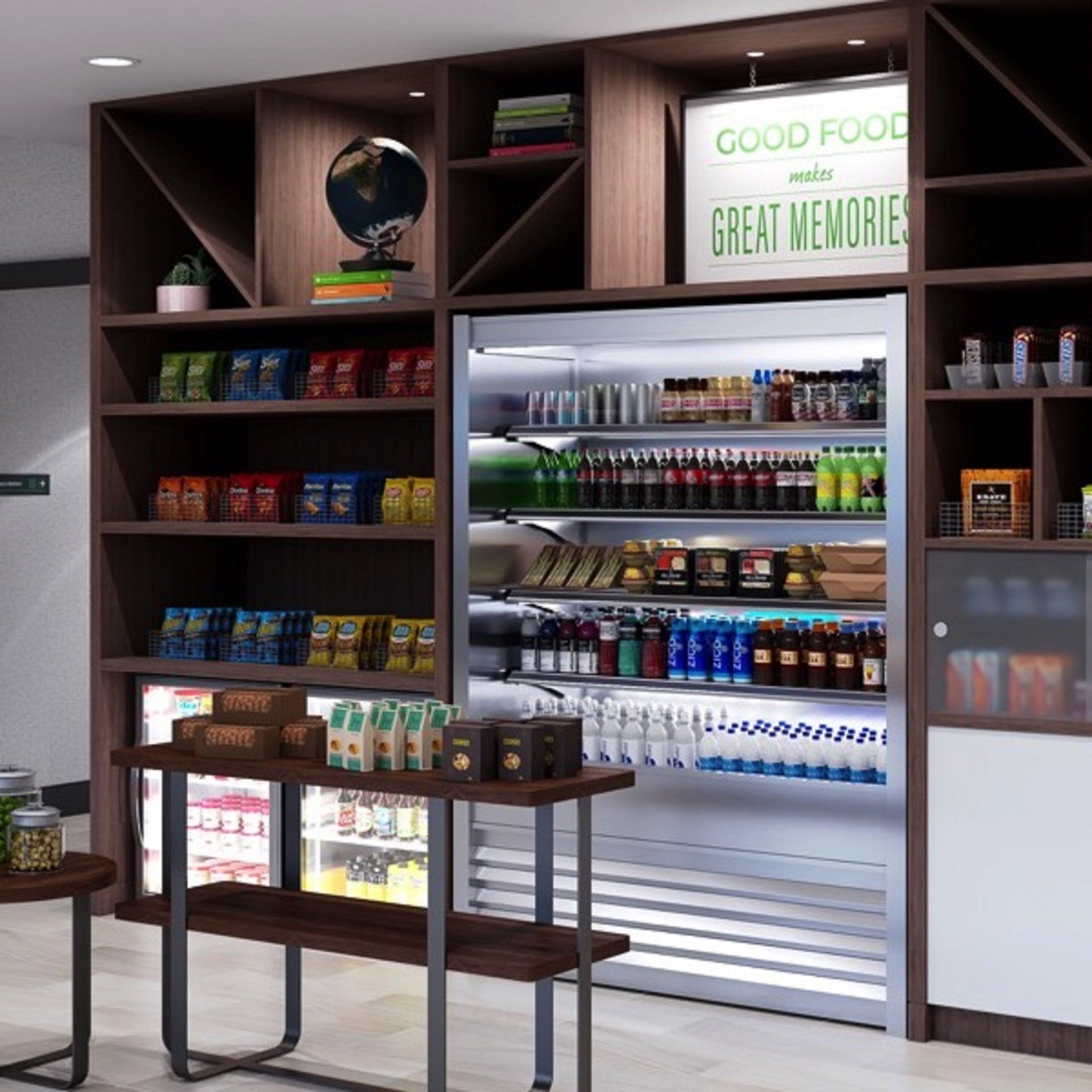 A snack bar with shelves stocked with various snacks, beverages, and a refrigerator.