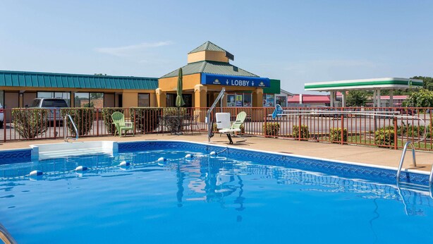 Una piscina con una fuente de agua azul, un área de recepción y una estación de servicio al fondo.