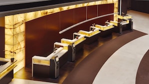 A reception area with a marble wall, multiple reception counters, and a modern design. - Hyatt Regency O'Hare Chicago (Rosemont)