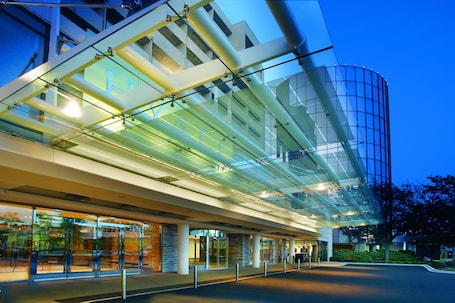 A modern building with a glass facade and a curved structure.