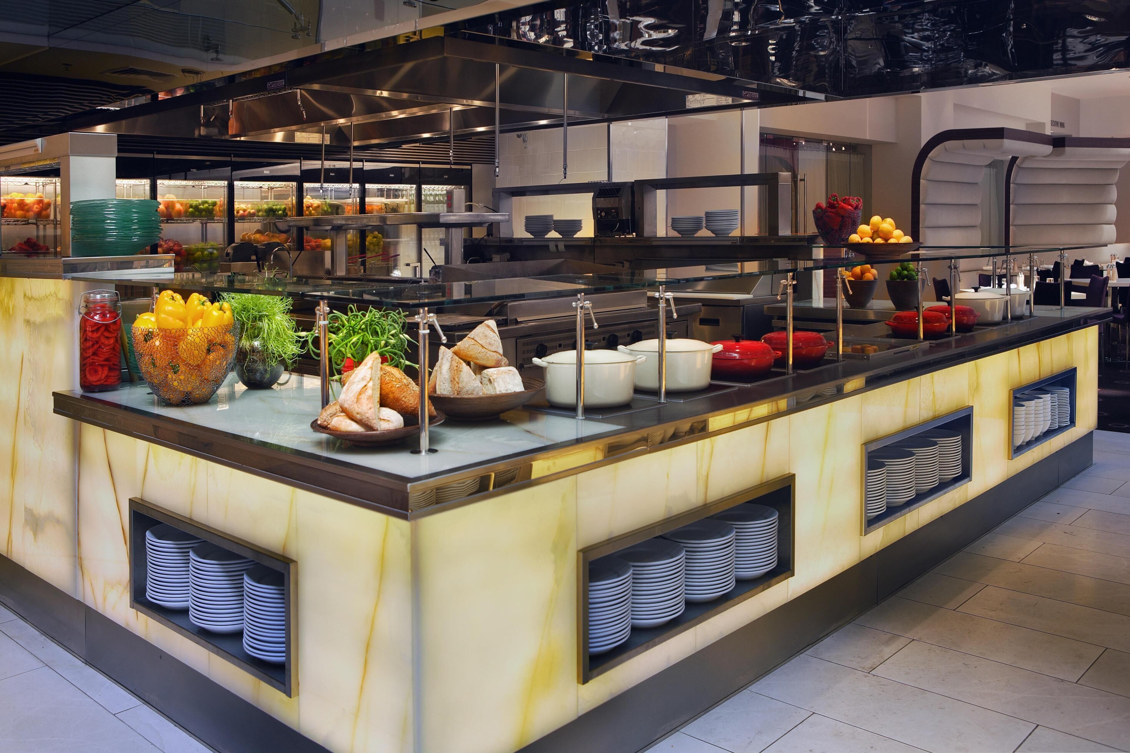 A buffet setup with various food items and utensils.