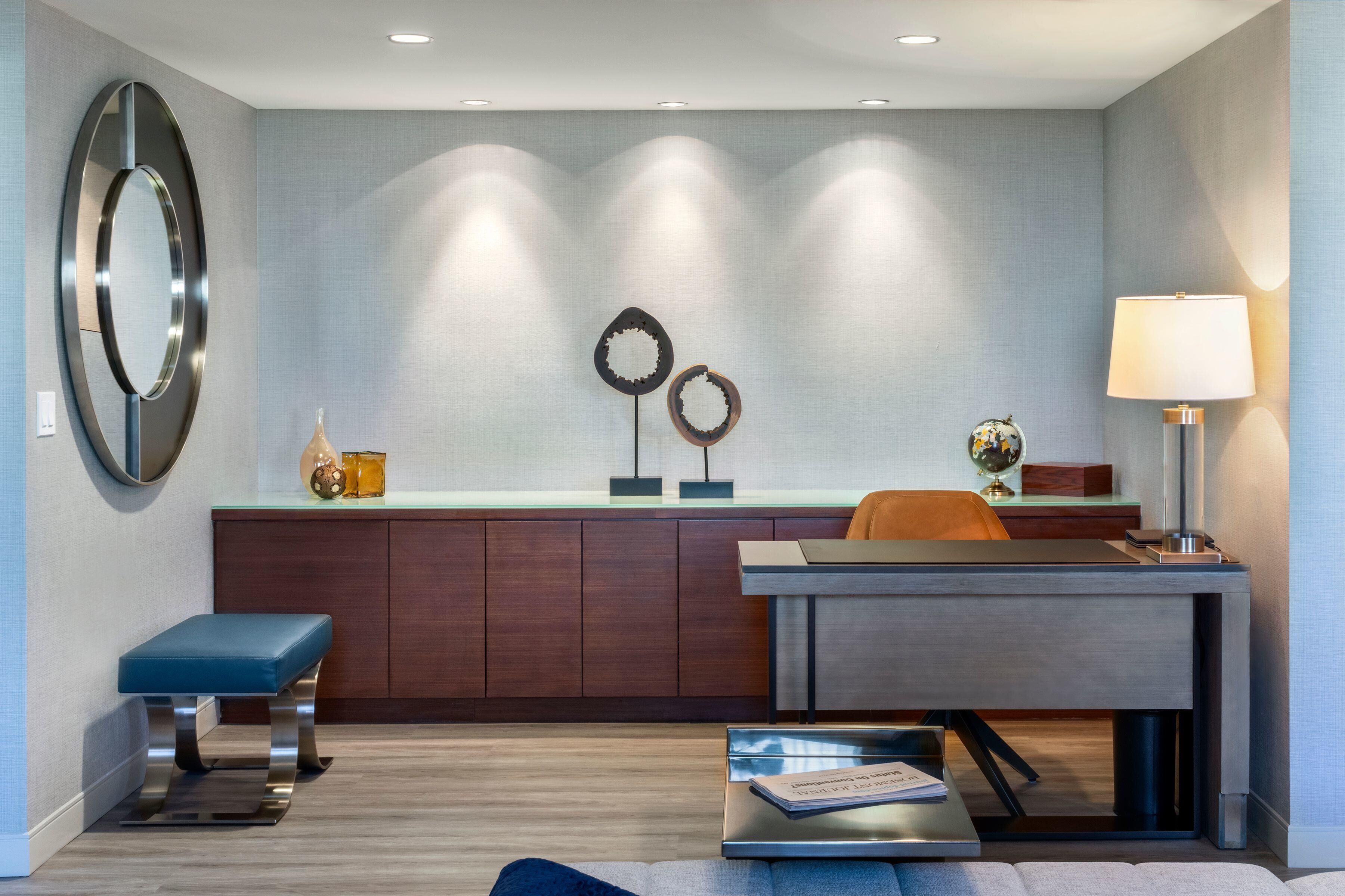 A modern interior with a desk, chair, and a blue bench.