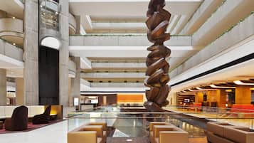 A modern interior with a central spiral sculpture, multiple levels, and seating areas.