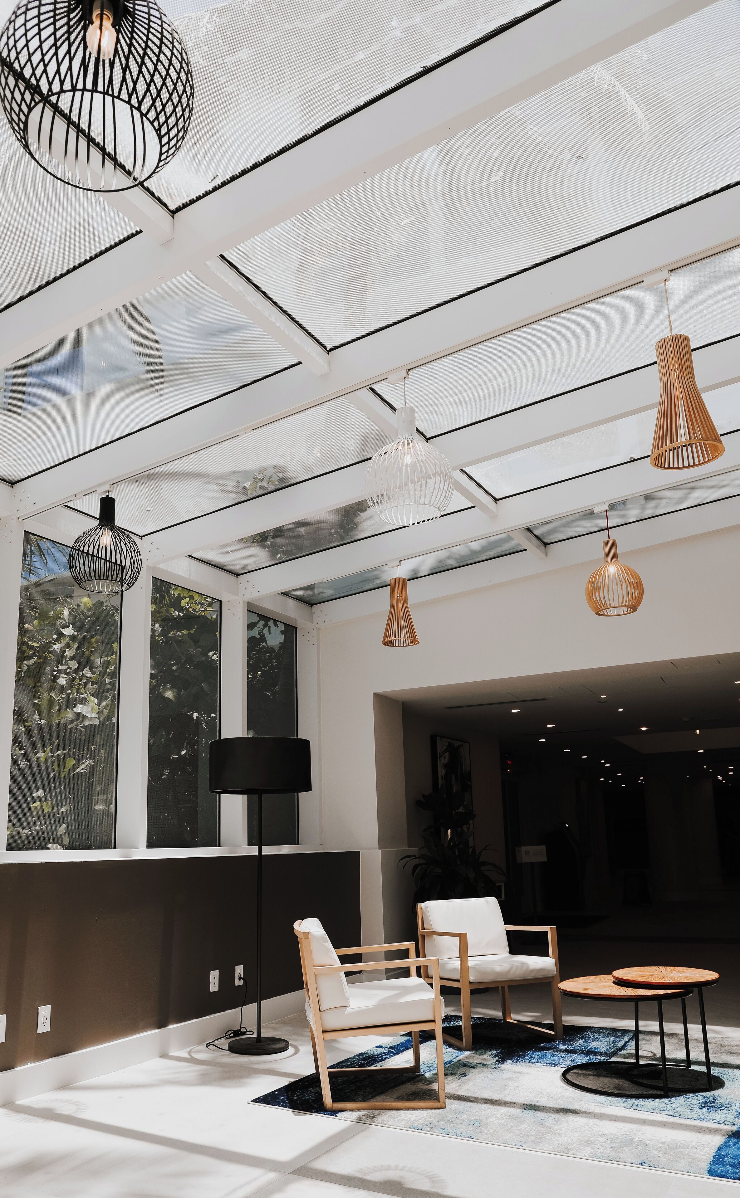 Un intérieur moderne avec un plafond haut, de grandes fenêtres et des meubles contemporains.