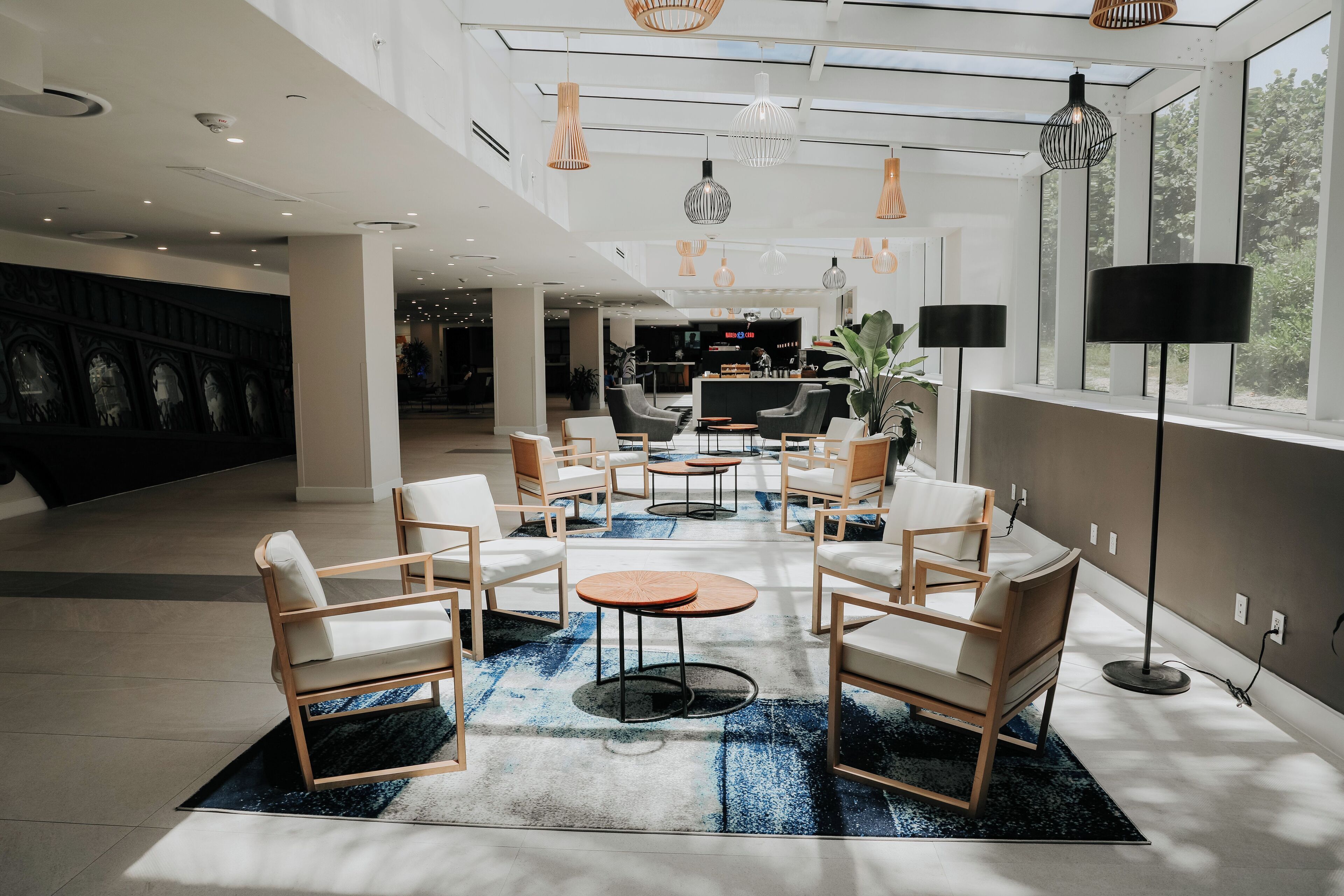 Un hall d’entrée spacieux, doté de meubles modernes, d’une grande fenêtre et d’un comptoir d’accueil situé au fond.