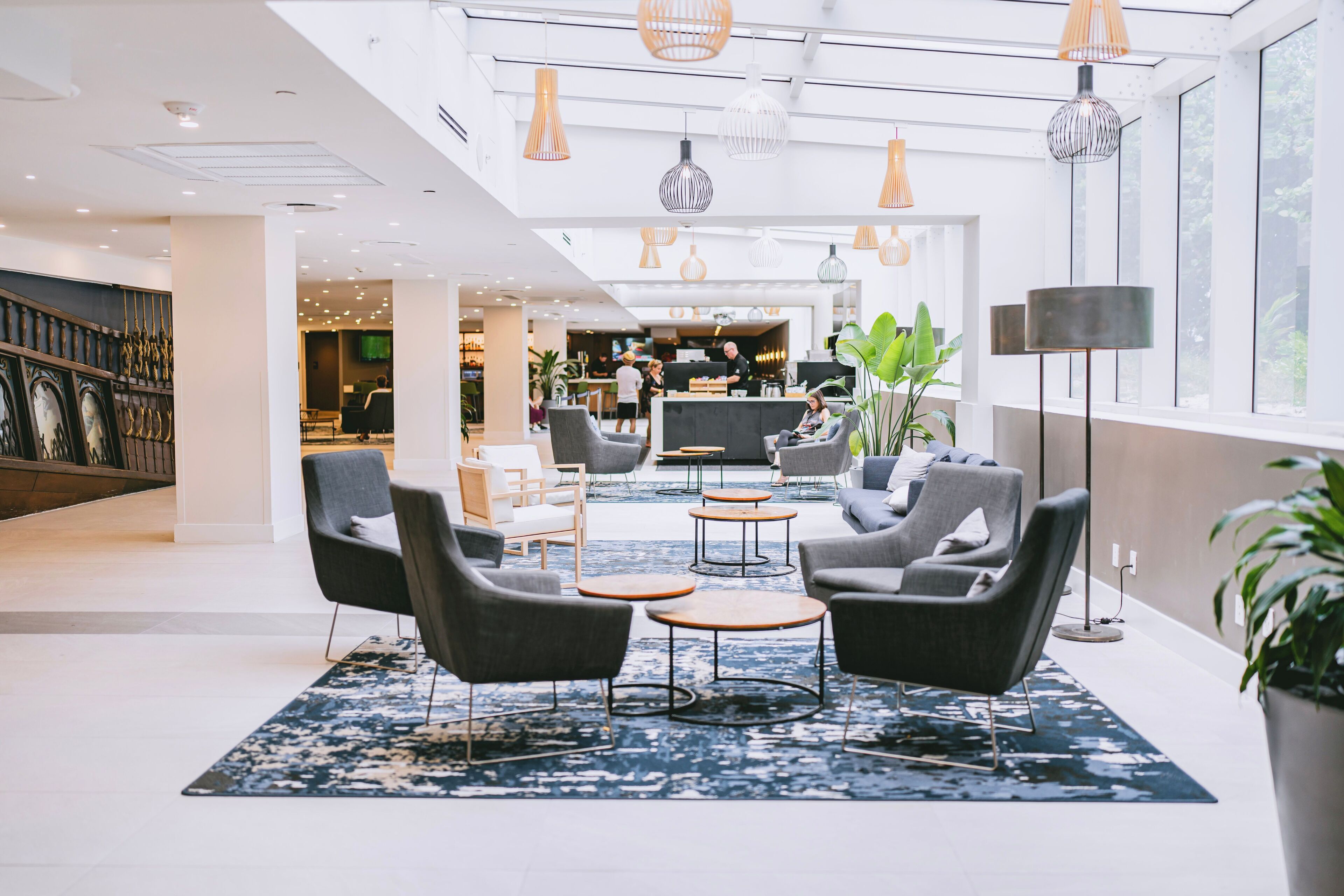 Een moderne lobby met zithoeken, een receptiebalie en grote ramen.