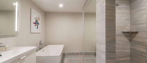 A modern bathroom with a freestanding bathtub, a large mirror, and a shower with a unique wall-mounted showerhead.