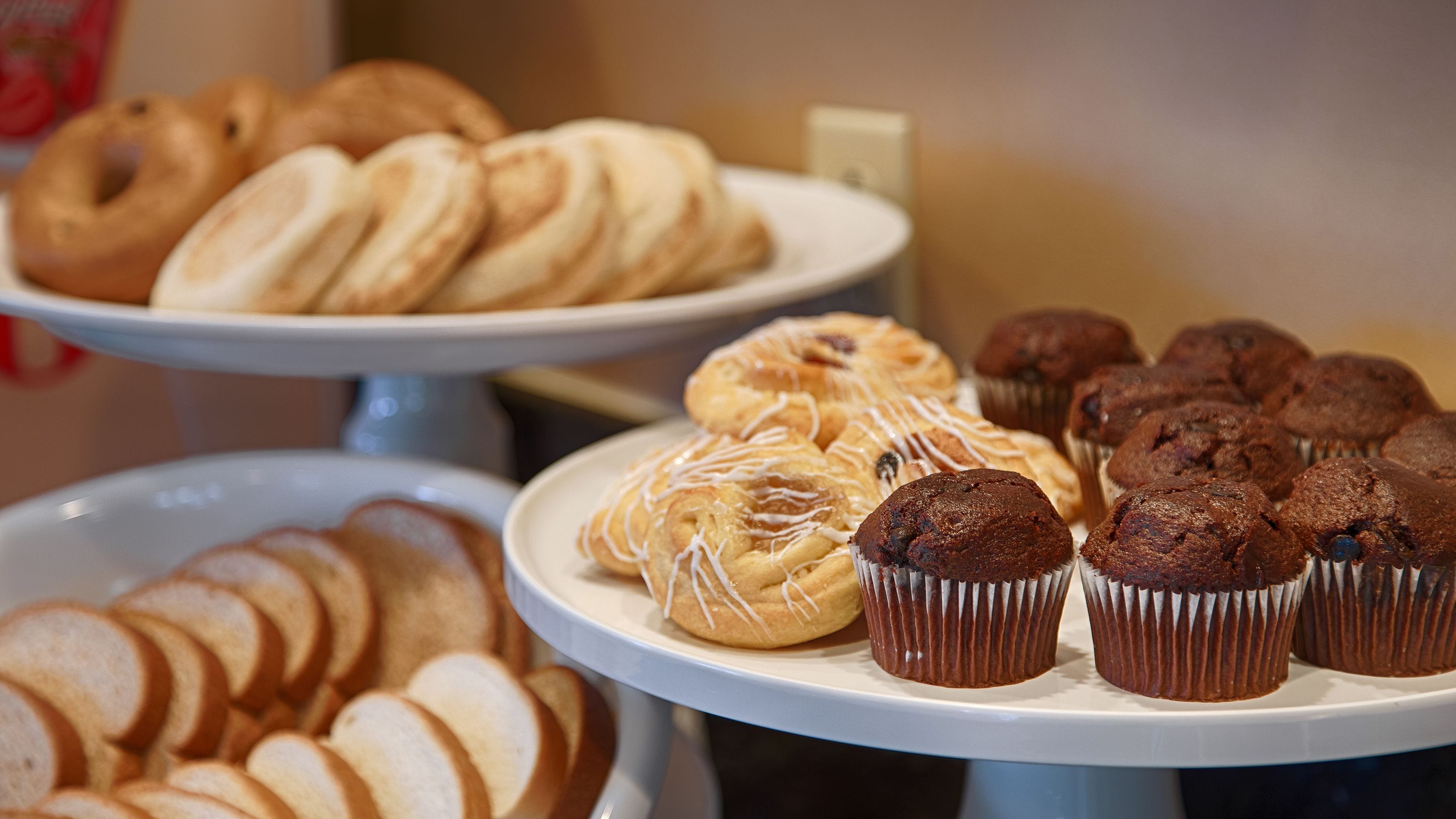 A variety of pastries displayed on three white stands.