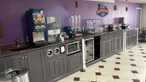 Een keukenhoek met een koffiezetapparaat, magnetron en een bordje met de tekst 'Ontbijthoek'.