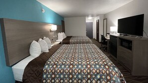 Een hotelkamer met twee bedden, een bureau, een televisie en een magnetron.