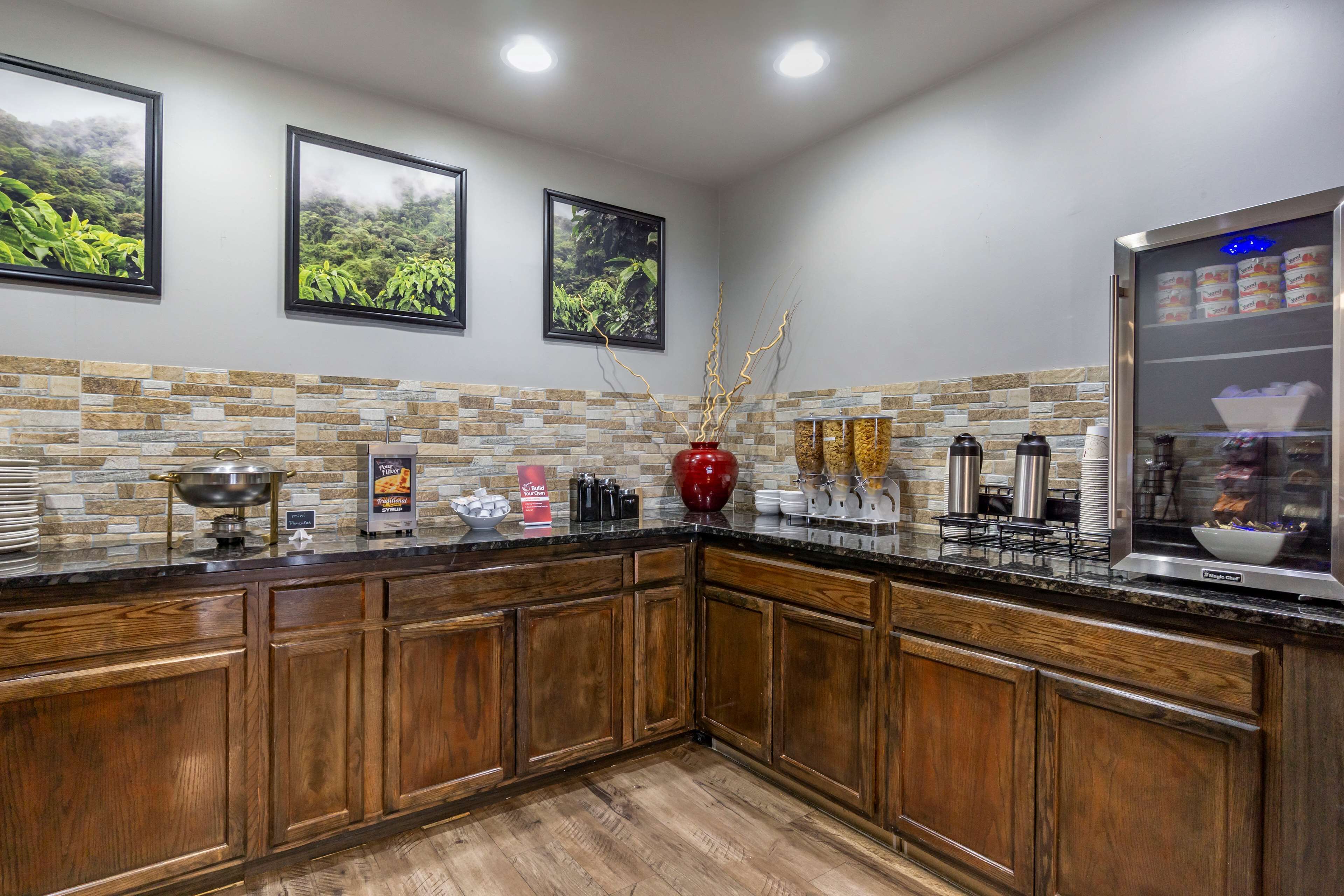 Cozinha com armários de madeira, painel de backsplash de pedra e um espaço para café.