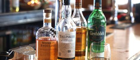 Varias botellas de whisky sobre una barra.