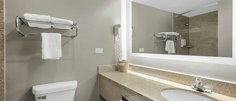 A modern bathroom with a toilet, sink, and towel rack.