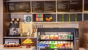 A Starbucks coffee shop with a menu board, coffee machines, and a refrigerated display of beverages. - Courtyard by Marriott Boston Marlborough (Marlborough)