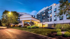 A Courtyard hotel with a modern design, featuring a well-lit entrance and landscaped grounds. - Courtyard by Marriott Boston Marlborough (Marlborough)
