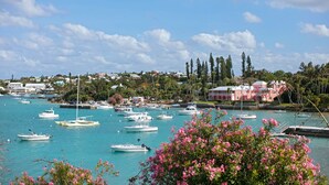 A marina with multiple boats docked, surrounded by residential buildings and lush greenery.
