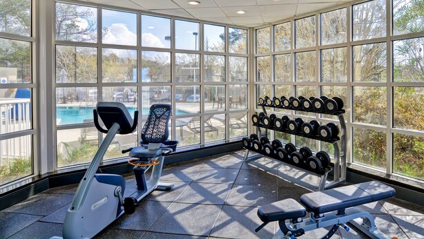 A gym with exercise equipment, a bench, and a rack of dumbbells. - Hampton Inn Mobile-East Bay/Daphne (Daphne)