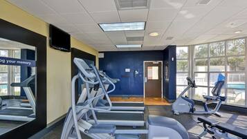 A gym with treadmills, an elliptical, and a bench press area.