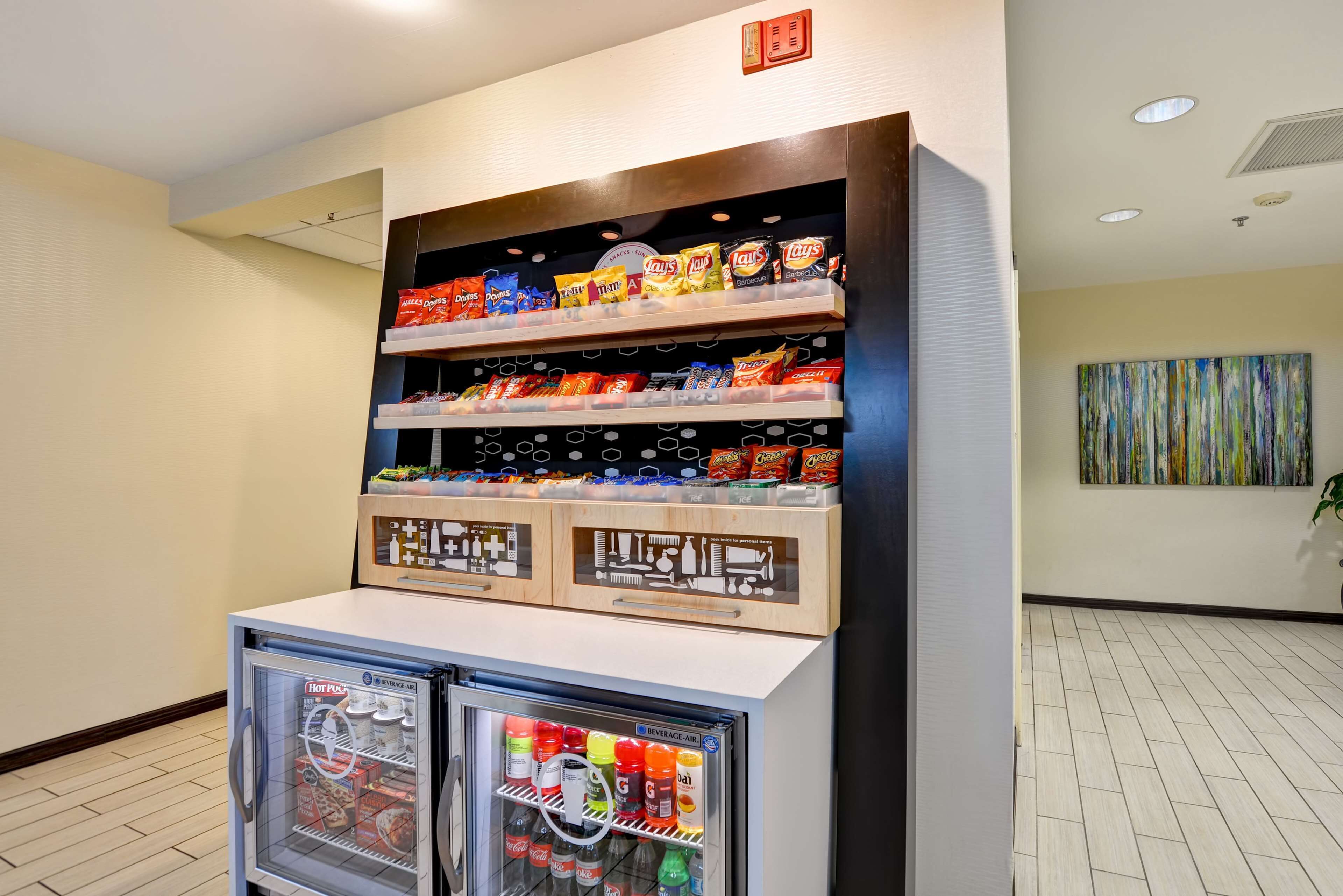 A snack display with various chips and a beverage cooler.