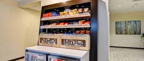 A snack display with various chips and a beverage cooler.