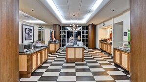 A hotel lobby with a checkered floor, wooden cabinets, a central island, and a chandelier. - Hampton Inn Mobile-East Bay/Daphne (Daphne)