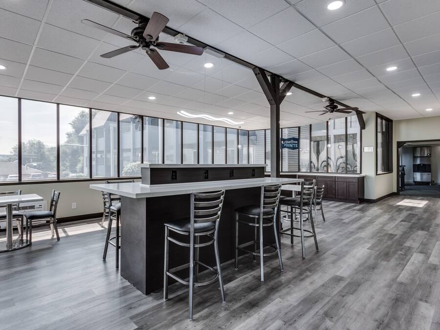 Una cocina moderna con barra, ventanas amplias y ventiladores de techo.