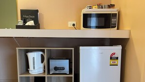A compact kitchenette with a microwave, toaster, and refrigerator. - Philadelphia Motor Inn Echuca (Echuca)