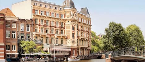 A historic building with a prominent dome and a bridge over a river.