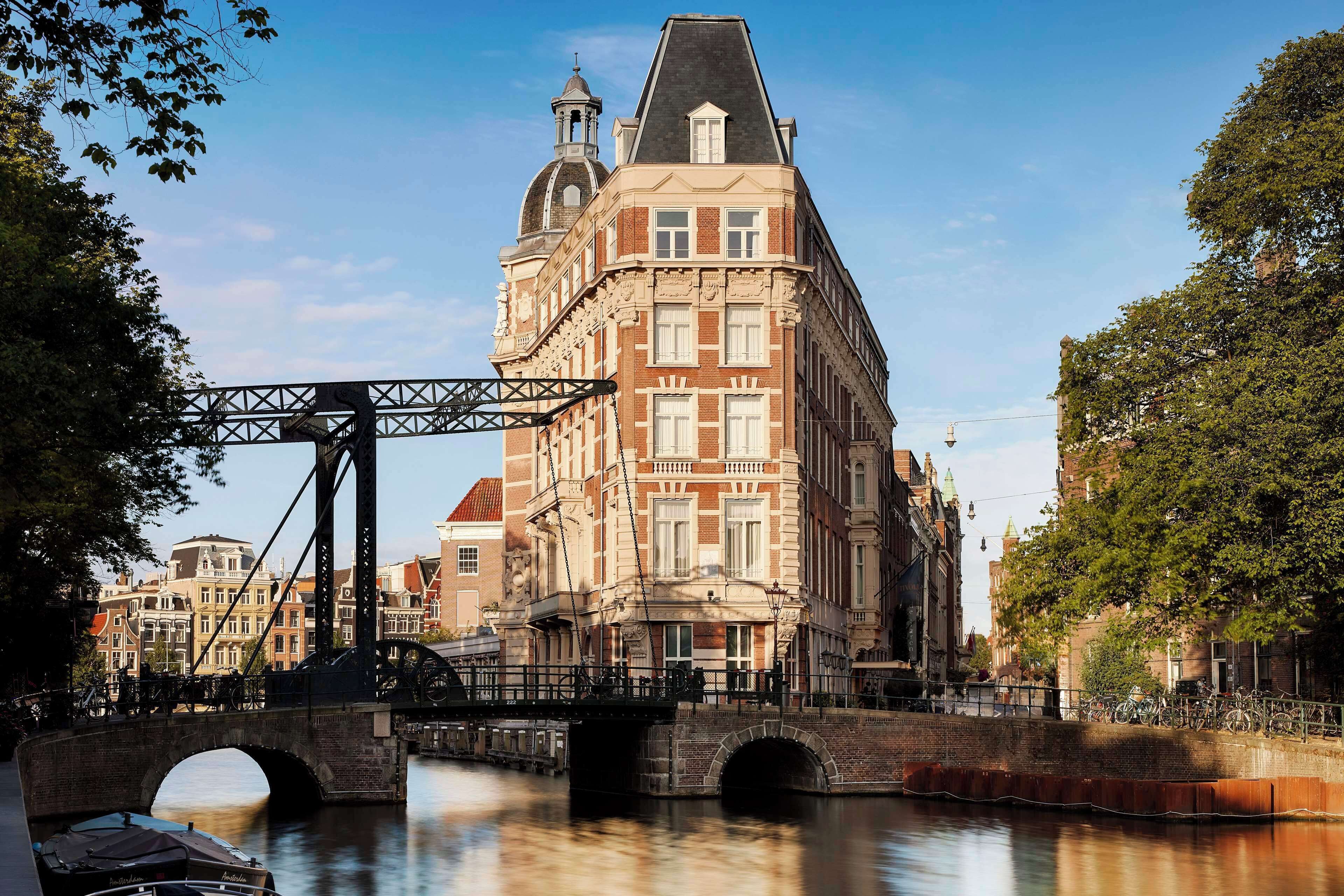 A historic building with a prominent tower, a bridge, and a canal.