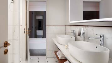 A modern bathroom with two sinks, a large mirror, and a shower area.