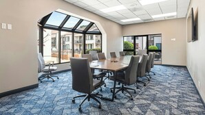 A conference room with a large table, chairs, and a view through a skylight. - Courtyard by Marriott Columbus (Columbus)