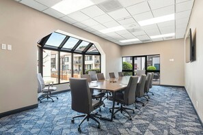 A conference room with a large table, chairs, and a view through a skylight. - Courtyard by Marriott Columbus (Columbus)