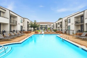 A swimming pool with lounge chairs and a view of apartment buildings. - Courtyard by Marriott Columbus (Columbus)