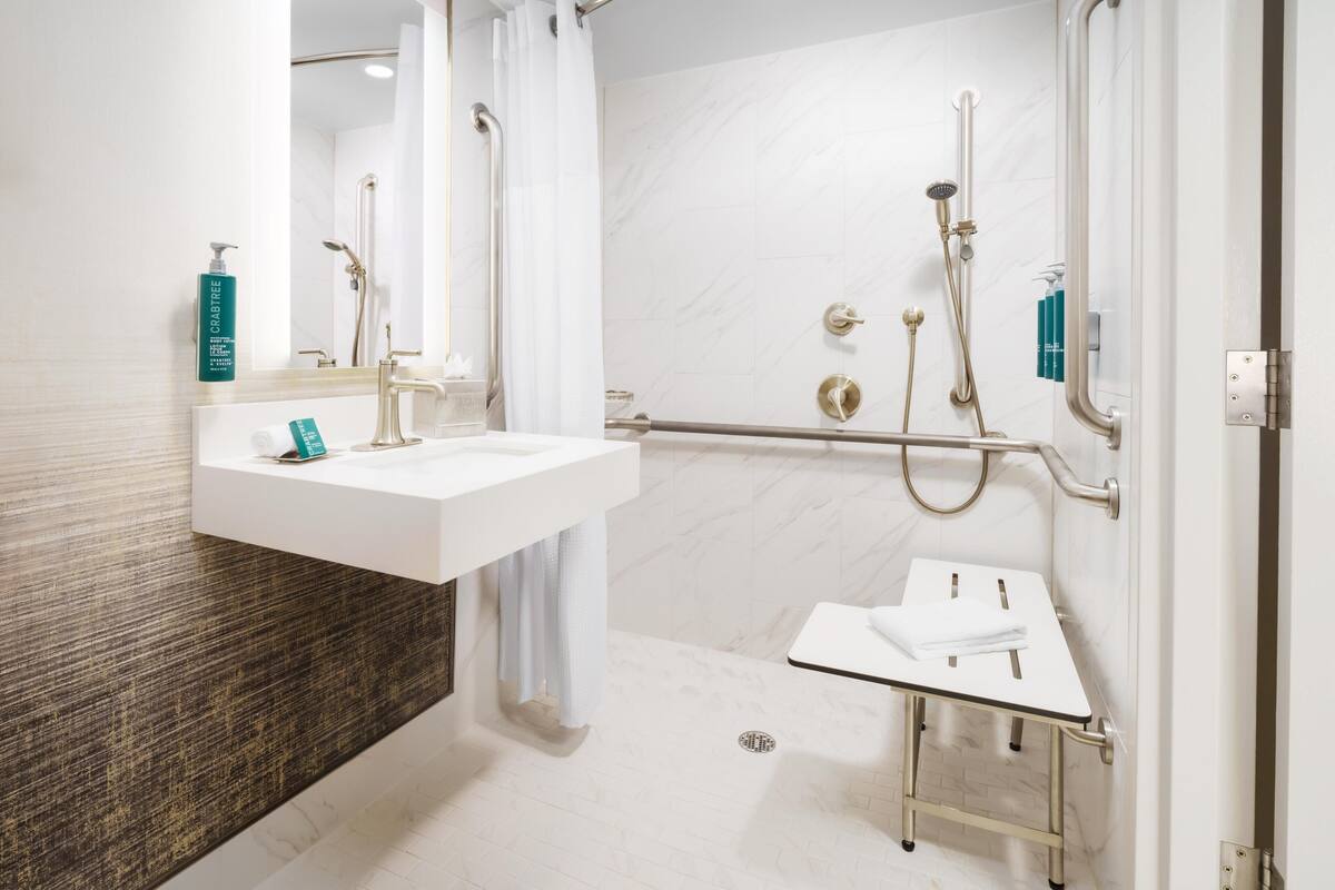 A modern bathroom with a white sink, a glass shower enclosure, and a separate vanity.